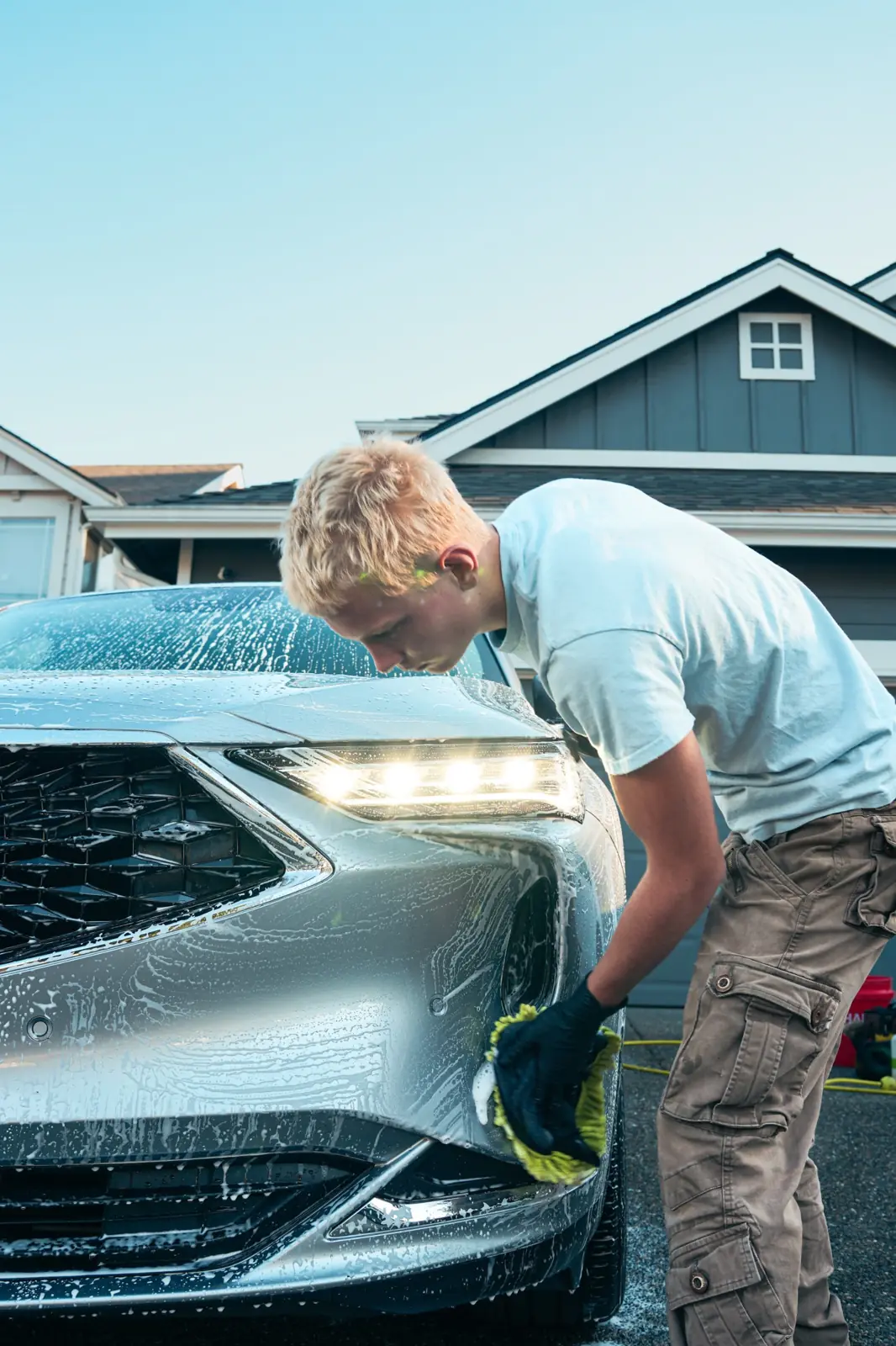 Detailer hand washing the front bumper of an Acura