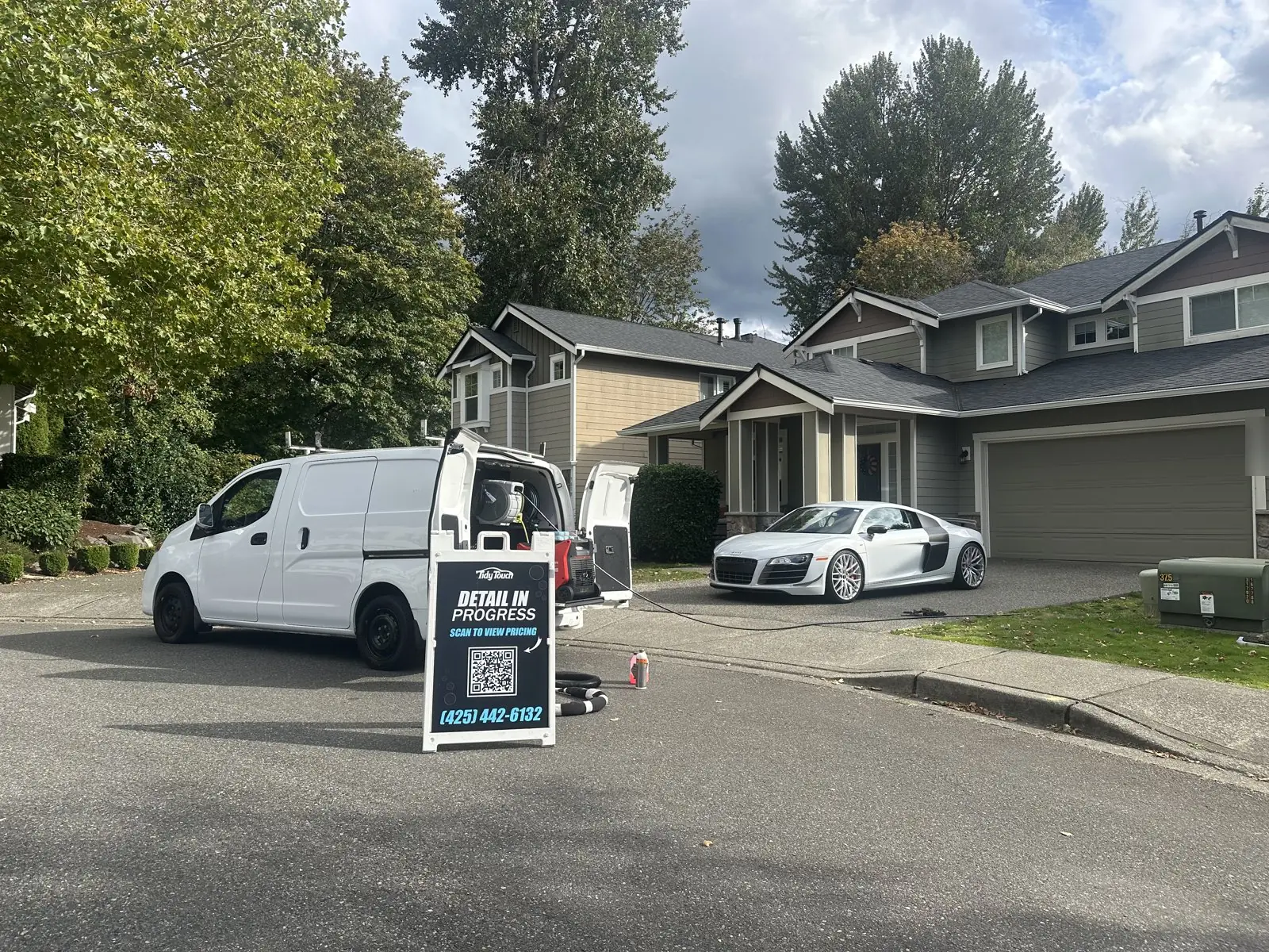 Tidy Touch van and Detail In Progress sign outside a home while an Audi R8 is detailed in the driveway