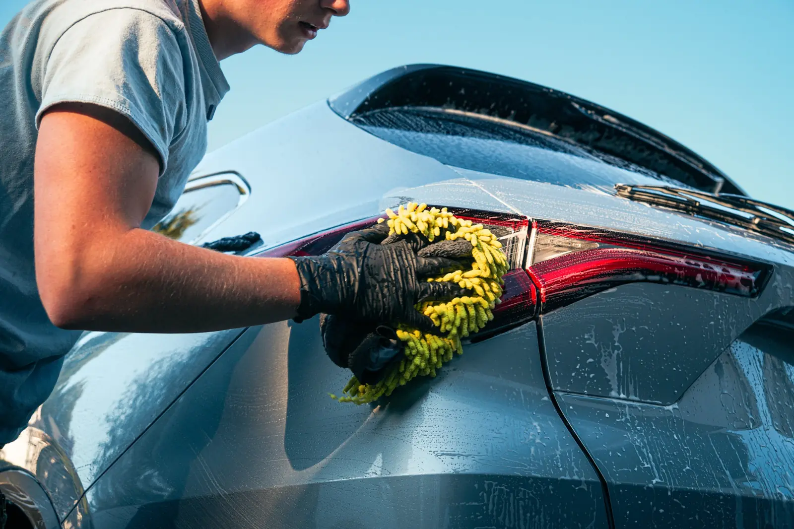 Microfiber wash mitt cleaning around a taillight